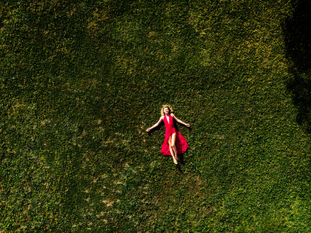 istock Beautiful Woman Lying on Green Grass 985289138