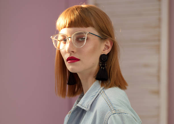 Fashionable redhead woman posing in studio.