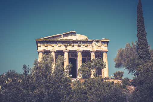 Temple of Hephaestus in Agora, Athens, Greece. It is one of the main landmarks of Athens. Beautiful view of the ancient Greek Temple of Hephaestus in summer. Scenic vintage postcard of Athens.