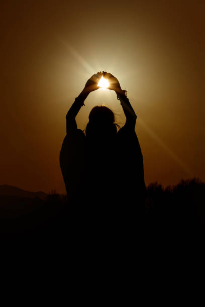 силуэт женщины руки, держась за солнце в треугольнике на фоне красивого заката - heaven women sunrise inspiration стоковые фото и изображения