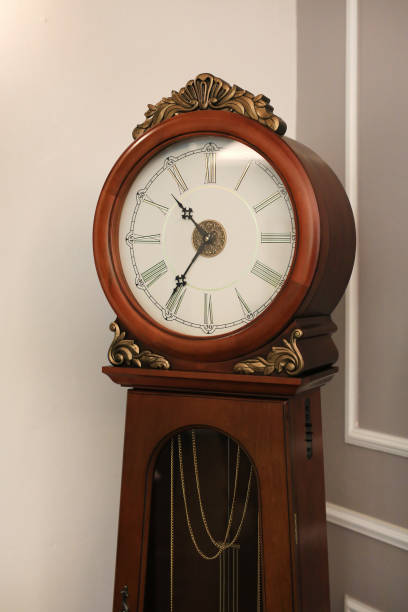 istock Antique style standing pendulum clock in the house. 985328258