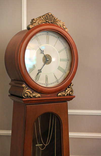 istock Ancient style standing pendulum clock in the house. 985328324