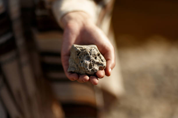 istock boho woman holding in hand moon shaped textured stone at river beach 985330214