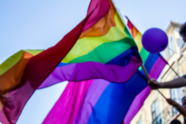 istock People waving LGBT rainbow flags at an gay pride parade 985331144