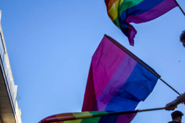 istock People waving LGBT rainbow flags at an gay pride parade 985331146