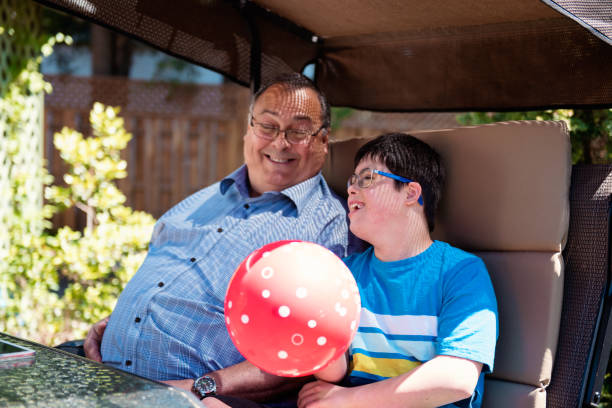 grand-père et son petit-fils de 12 ans atteints d’autisme et le syndrome de down dans la vie quotidienne - 10 11 years cheerful happiness fun photos et images de collection