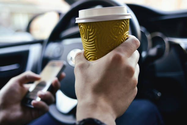 istock Male hold coffee and drive the car 985339604