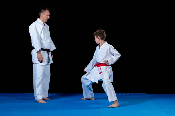istock Male karate instructor training little children in dojo 985343520