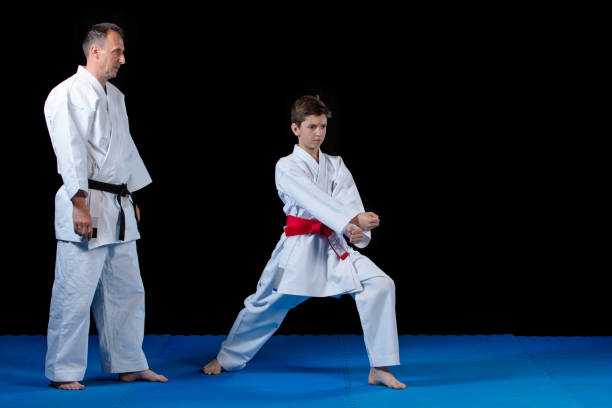 istock Male karate instructor training little children in dojo 985346736