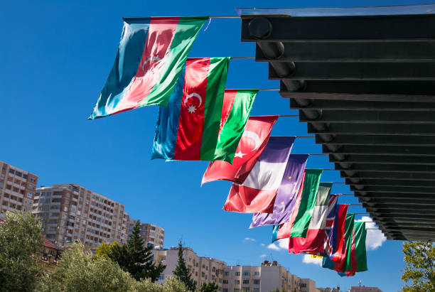 азербайджан и другие флаги развеваются на ветру в баку. азербайджан. - southeastern region фотографии стоковые фото и изображения