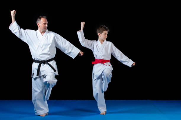 istock Male karate instructor training little children in dojo 985351360