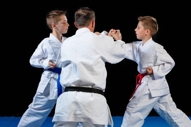 istock Male karate instructor training little children in dojo 985353860