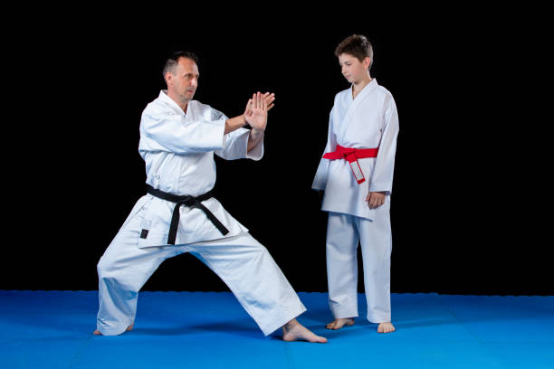 istock Male karate instructor training little children in dojo 985354552