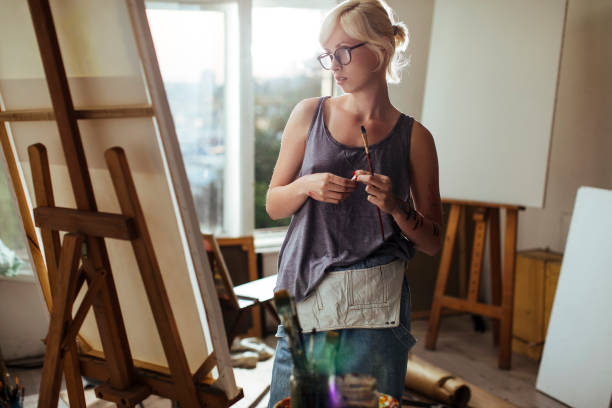 istock Girl painting on canvas 985354904