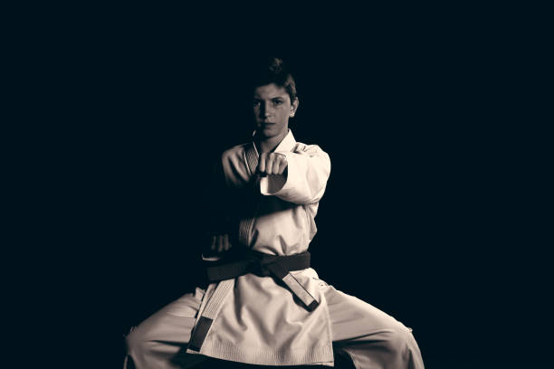 Young boy dressed in a white karate kimono with red belt