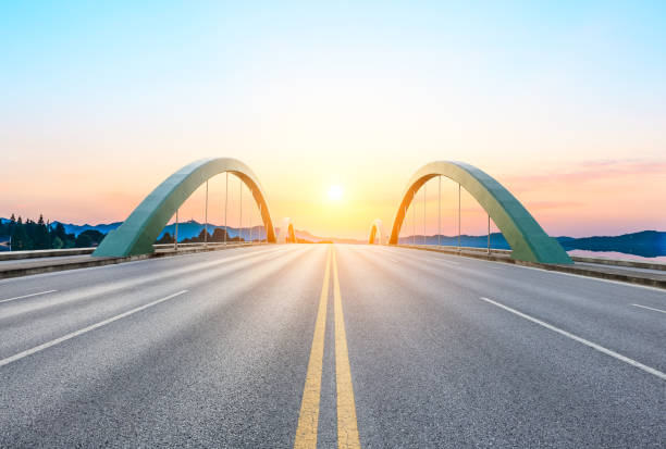 istock asphalt road and bridge at sunset 985359006