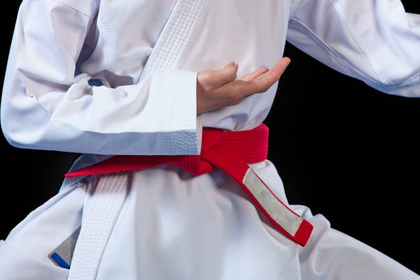 istock Aikido red belt on white kimono on black background 985371626