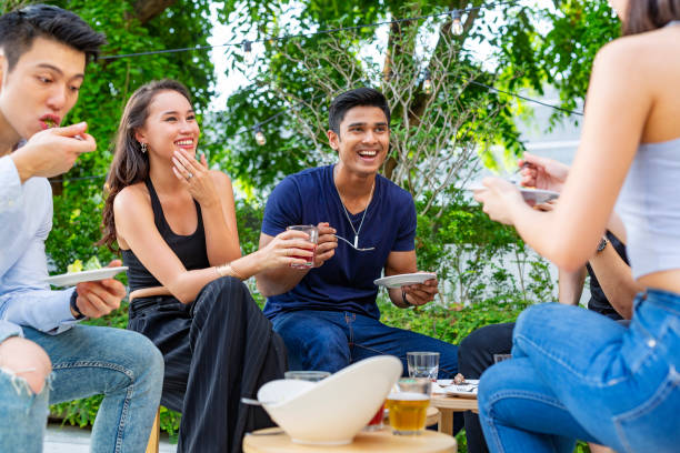 istock Happy Young Asian People Having Fun Eating and Drinking at a Party 985371690