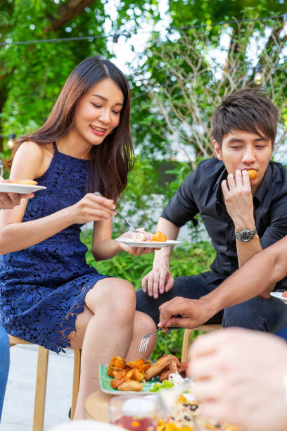istock Happy Young Asian People Having Fun Eating and Drinking at a Party 985371722