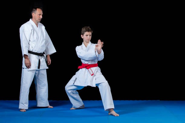 istock Male karate instructor training little children in dojo 985374052