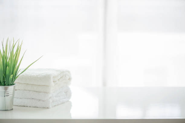 Towels and houseplant on white table with copy space. For product display montage.