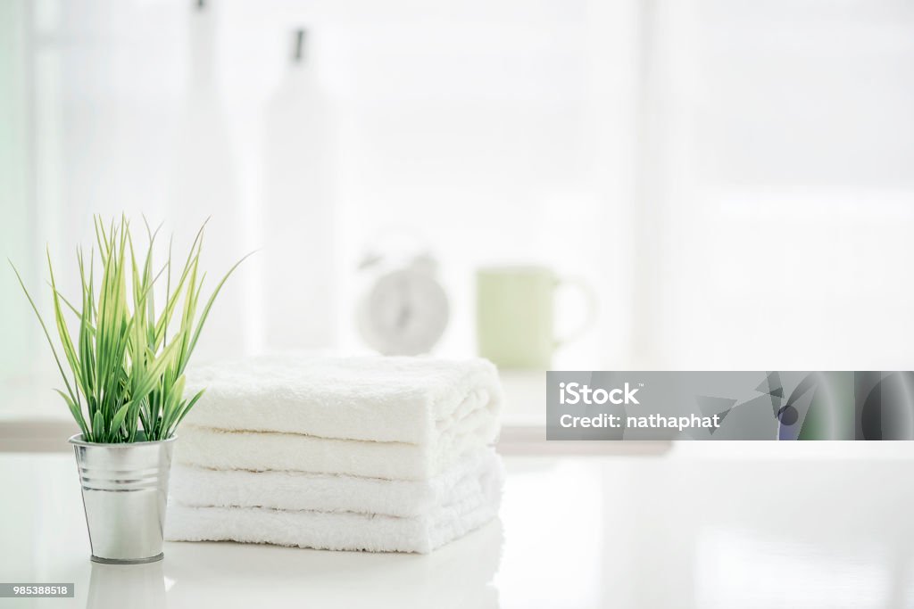 Towels on white table with copy space on blurred bathroom background Towels on white table with copy space on blurred bathroom background. For product display montage. Bathroom Stock Photo