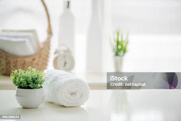 Roll Up Of White Towels On White Table With Copy Space On Blurred Living Room Background Stock Photo - Download Image Now