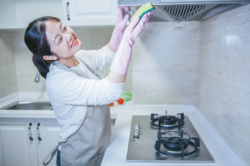 Beautiful woman cleaning in kitchen