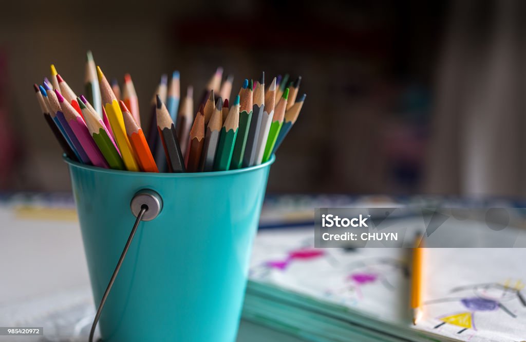 Happy colors Bucket of color pencils with sketching notebook. Bucket Stock Photo