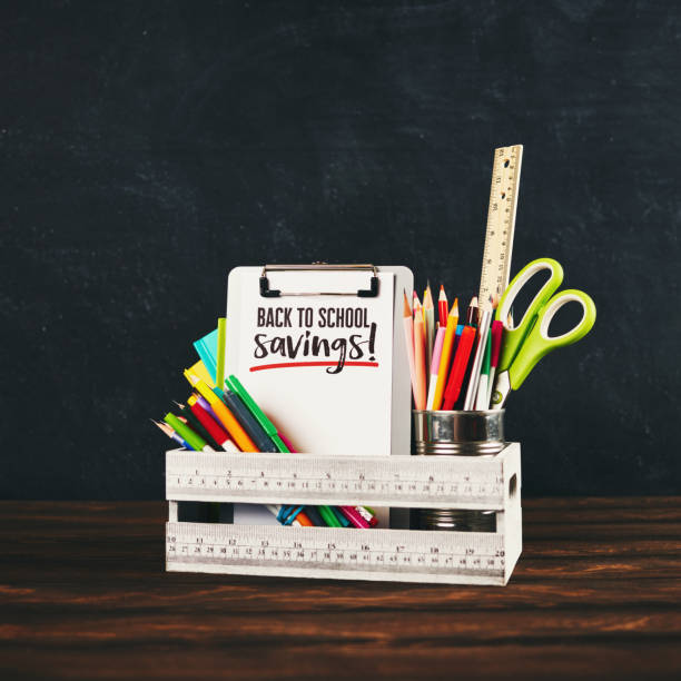 istock Back to school supplies with clipboard against weathered chalkboard 985421996