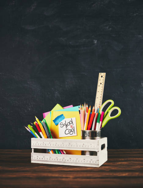 istock Back to school supplies in crate against weathered chalkboard 985422064