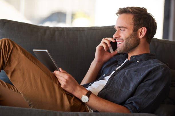 istock Happy cucasian man smiling on the phone while holding tablet 985431966