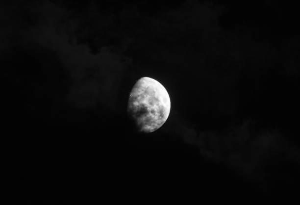 istock gorgeous moon in a dark blue night sky gets covered by soft wispy dark clouds 985469226