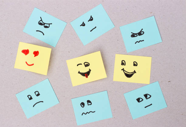 istock Unhappy smilies and a happy faces painted on office stickers 985469610