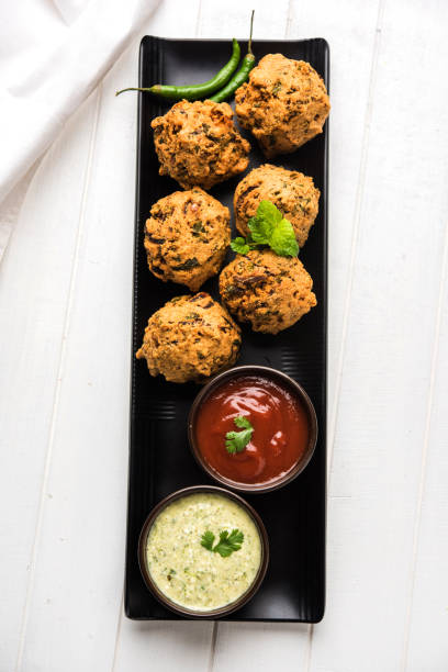 istock Palak OR Methi Pakora is an Indian Snack served with Green mint chutney and red Sauce, selective focus 985480708
