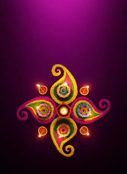 Diwali celebration - Diya oil lamps lit on colorful rangoli
