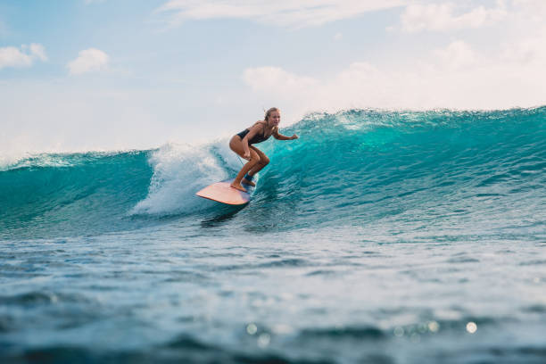 istock Surfer girl on surfboard. Surfer and wave 985499148