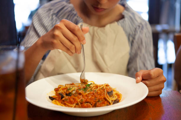 Pasta on fork with tomato and red pepper sauce.