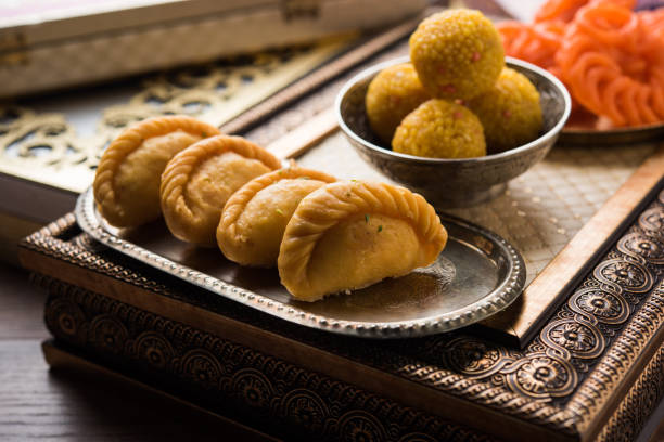 dulce indio jalebi/imarti, laddu y gujiya sirven juntos sobre fondo blanco o con regalos. enfoque selectivo - gujia fotografías e imágenes de stock