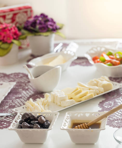 istock Turkish breakfast with white porcelain plates and flowers on background 985513048
