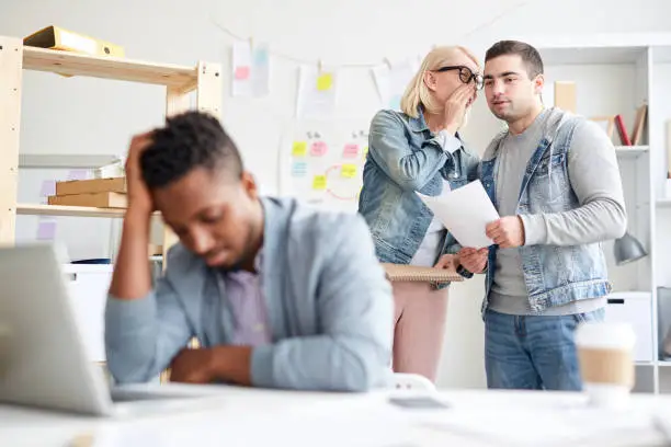 Office colleagues gossiping about new employee