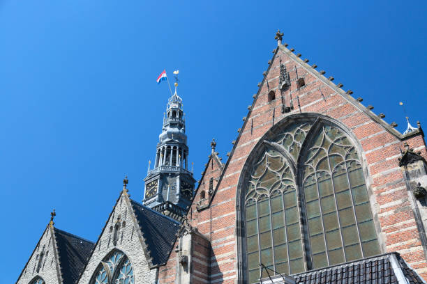 Old Church Oude Kerk the oldest building in De Wallen Amsterdam, Netherlands against blue sky. Old Church Oude Kerk the oldest building in De Wallen Amsterdam, Netherlands against blue sky wellen stock pictures, royalty-free photos & images
