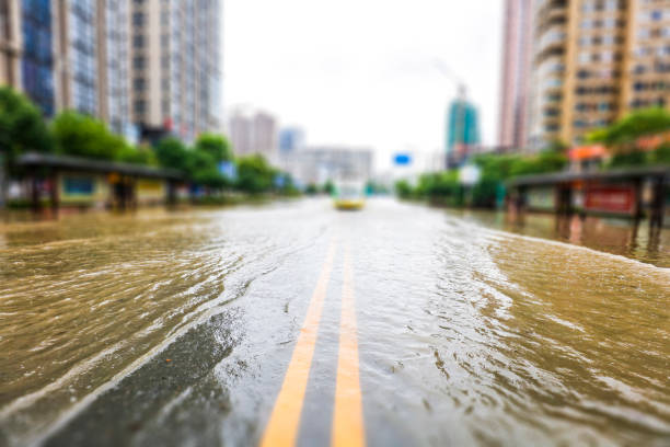 rues inondées par fortes pluies dans la ville. le fond de la construction urbaine et de la gestion. - flood photos et images de collection
