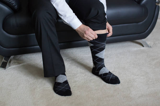Business man putting on dress socks stock photo