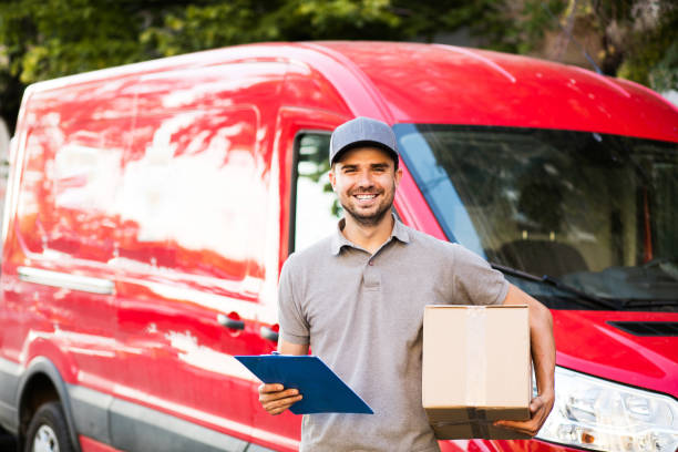 delivery man with cardbox in hands on the streets stock photo