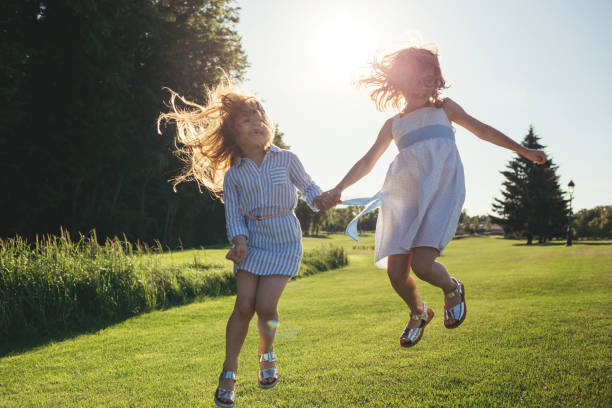 istock Two cheerful girls jumping against the sunset. 985558054