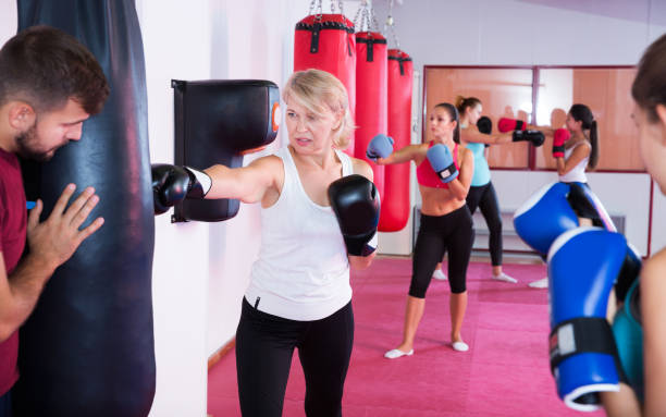 istock mature woman who is training with punching bag 985559028