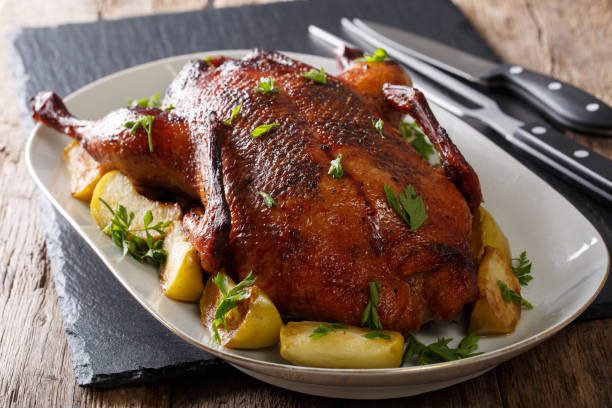 istock Festive baked duck with apples close-up on a table. horizontal 985569122