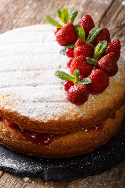istock Victoria sandwich cake decorated with strawberries and mint closeup. vertical 985569794