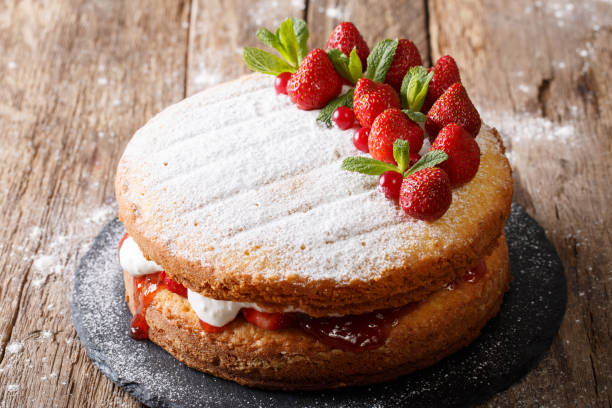 istock Home Victoria sponge cake, decorated with strawberries and mint closeup. Horizontal 985577140